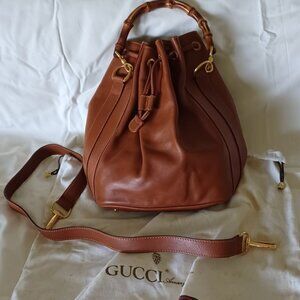 Never used vintag Gucci bucket with bamboo handle and adjustable shoulder strap.